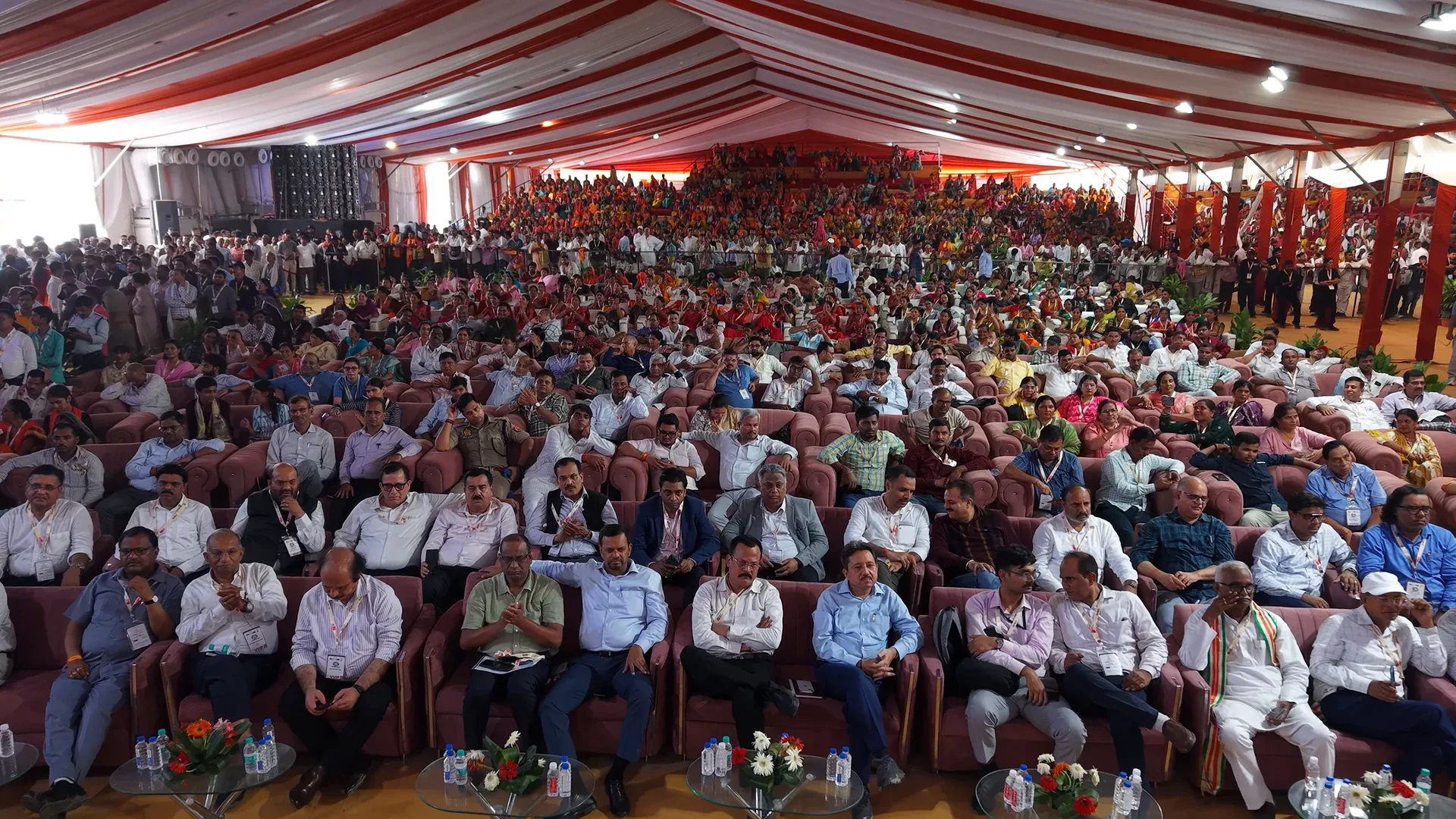 A large audience gathered beneath a striped event canopy in RANGEELO.